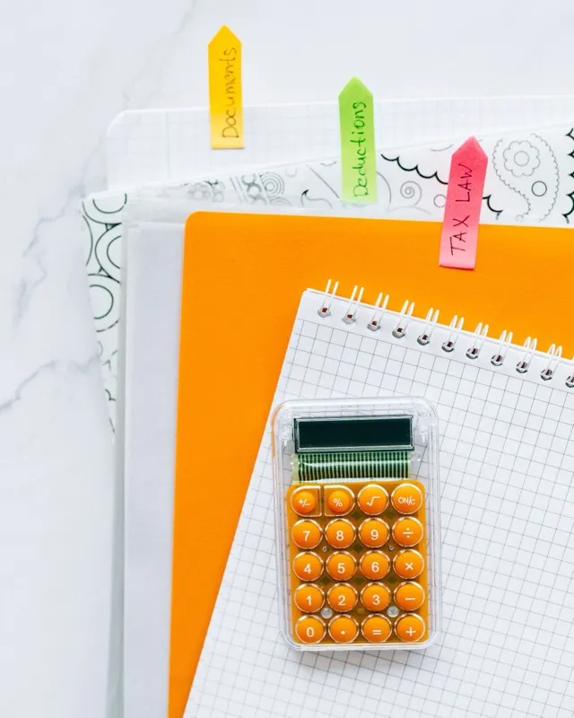 Calculator, notepad and folders tabbed for documents and tax law